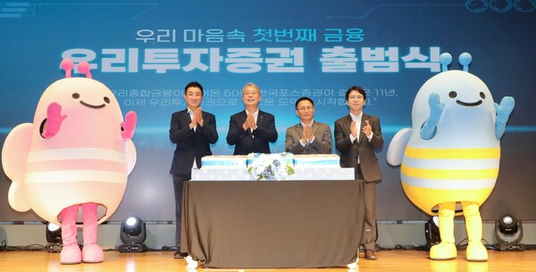 Woori Financial Group Chairman Yim Jong-ryong (second left), Woori Investment & Securities CEO Nam Ki-cheon (third left) and officials at the securities firm pose for photos during an inauguration ceremony held at the firm's headquarters in Yeouido, western Seoul, Thursday. (Woori Investment & Securities)