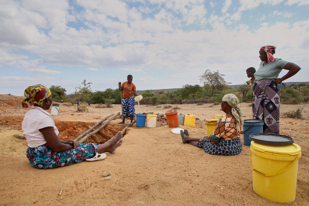 Women make use of their turn to draw water at a village well, which has very limited reserves of water left to meet their household water needs for drinking, cooking and sanitation as the water table has been severely depleted as the El-Nino induced drought, in Mudzi on July 2. (AFP)