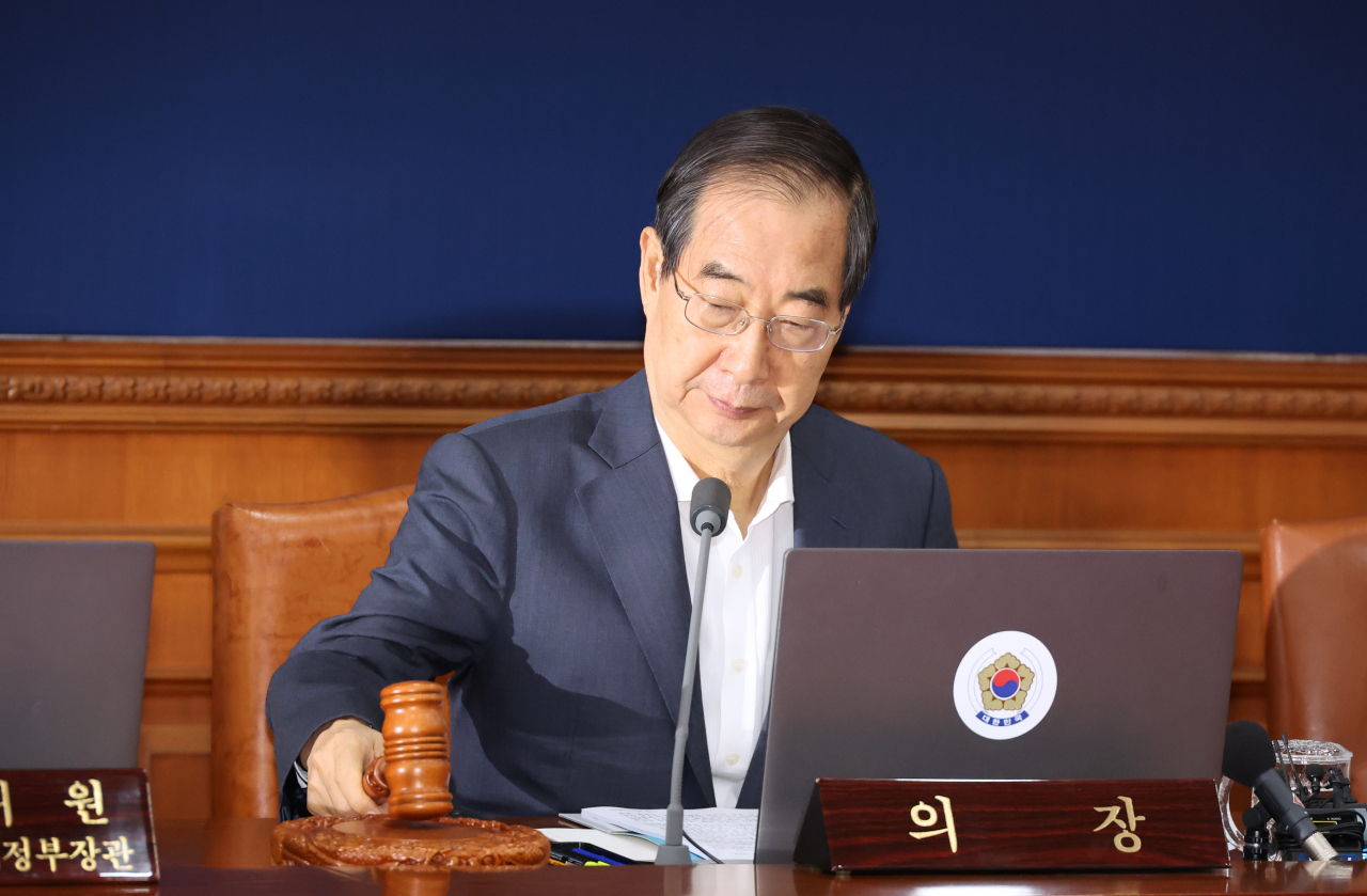 Prime Minister Han Duck-soo bangs the gavel during a Cabinet meeting at the government complex in Seoul on Tuesday. (Yonhap)