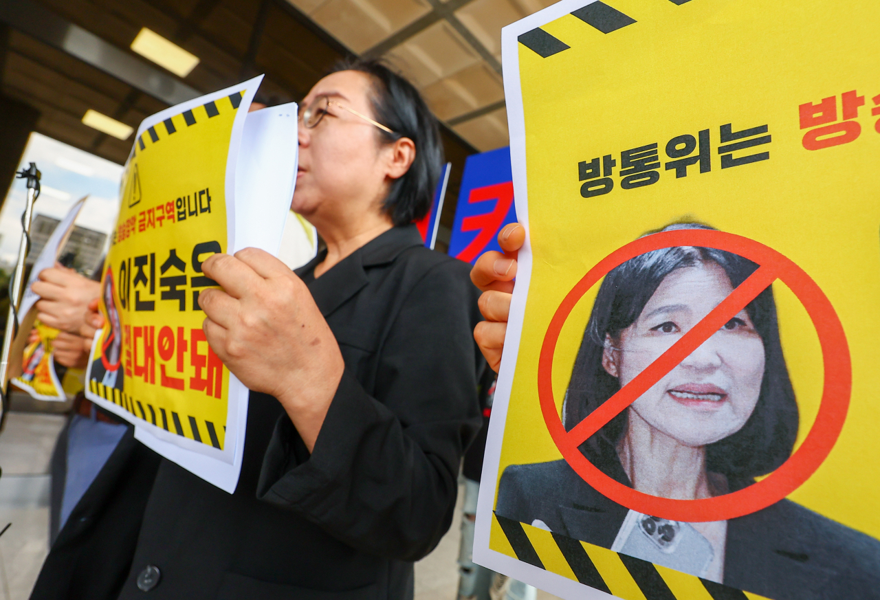 Labor union members of South Korean journalists hold placards while filing a complaint against Lee Jin-sook, chief of the Korea Communications Commission, at the Seoul Central District Prosecutors' Office, July 31. (Yonhap)