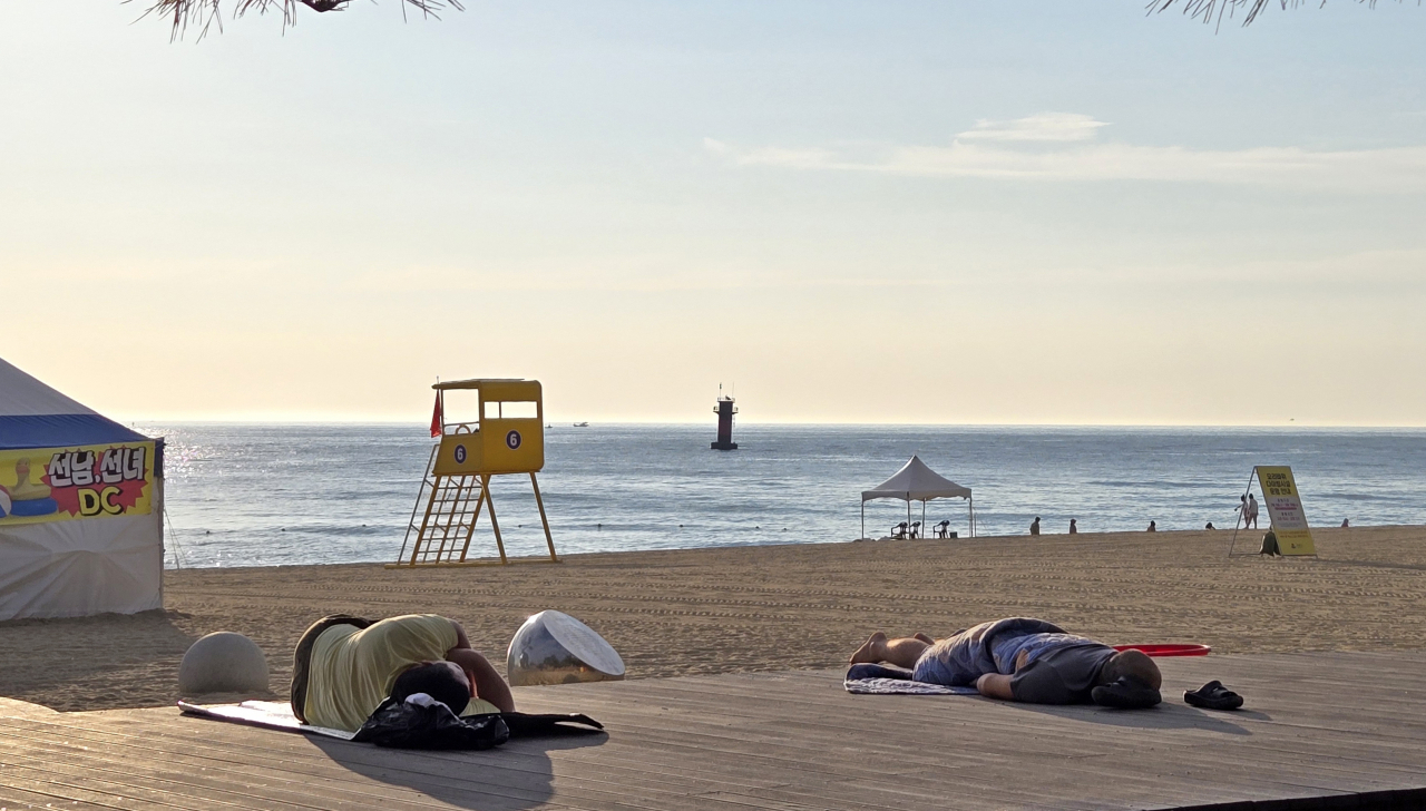 Local residents sleep overnight on Gyeongpo Beach in Gangneung, Gangwon Province, Wednesday, to escape the persistent tropical night that has lasted for 19 days in the city. (Yonhap)