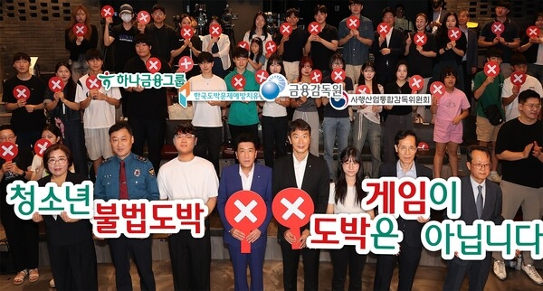 Hana Financial Group Chairman Ham Young-joo (center left, front row) and Financial Supervisory Service Gov. Lee Bok-hyun (center right, front row) pose for a photo along with partnering officials, youngsters and their parents at the launch event of a new anti-gambling campaign in Seoul, Friday. (Hana Financial Group)