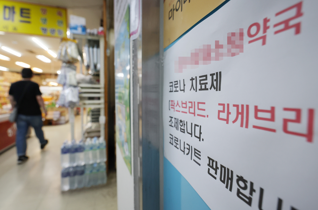 A notice in front of a pharmacy reads that it sells COVID-19 antiviral medicines. (Yonhap)