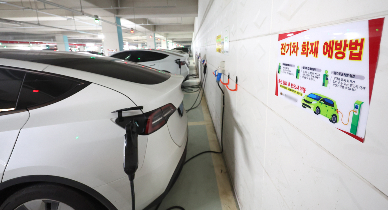 A notice on fire prevention for electric vehicles is posted at an EV charging station in the underground parking lot of an apartment complex in Yeonsu District, Incheon, on Monday. (Yonhap)