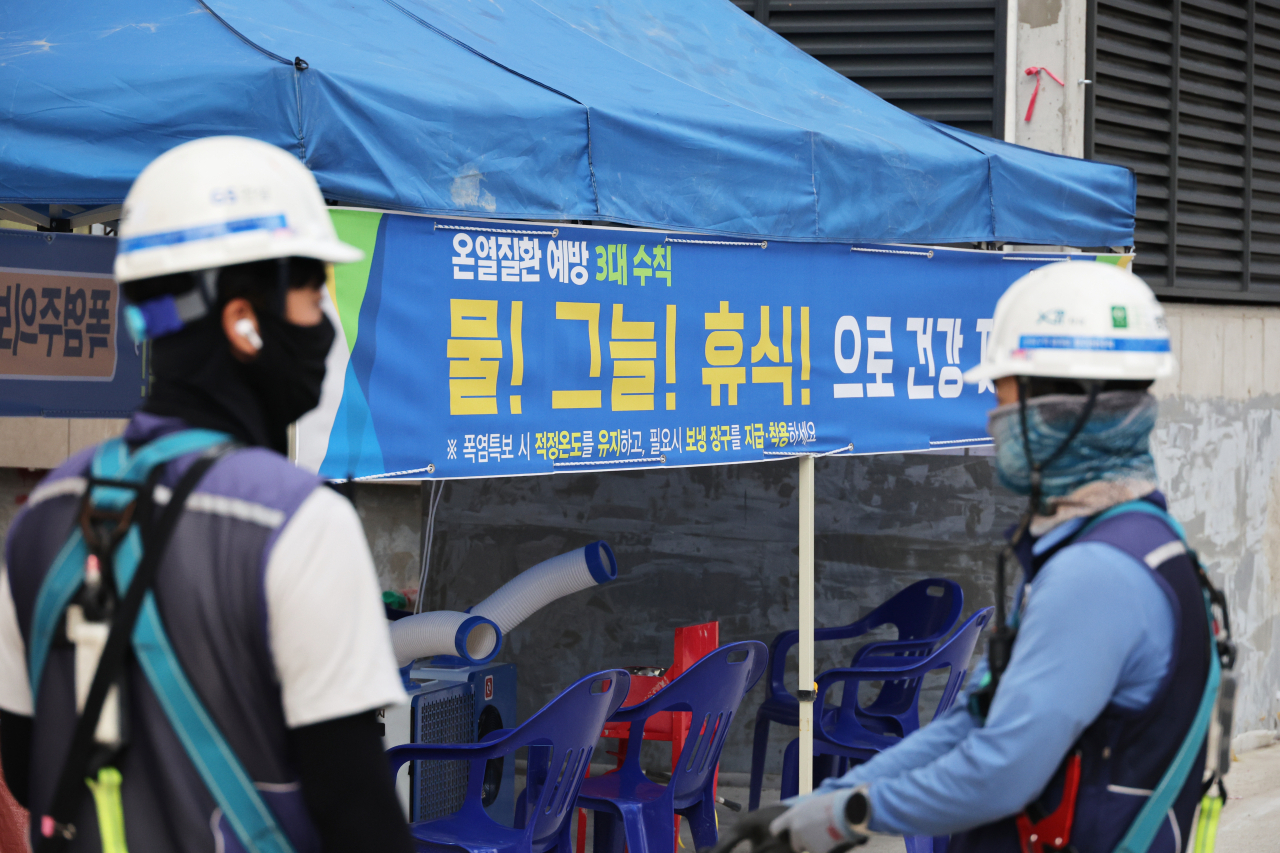 A banner telling workers to drink water, stay in shade and rest regularly to prevent heat-related illness is seen at a construction site in Seoul on Aug. 8. (Yonhap)