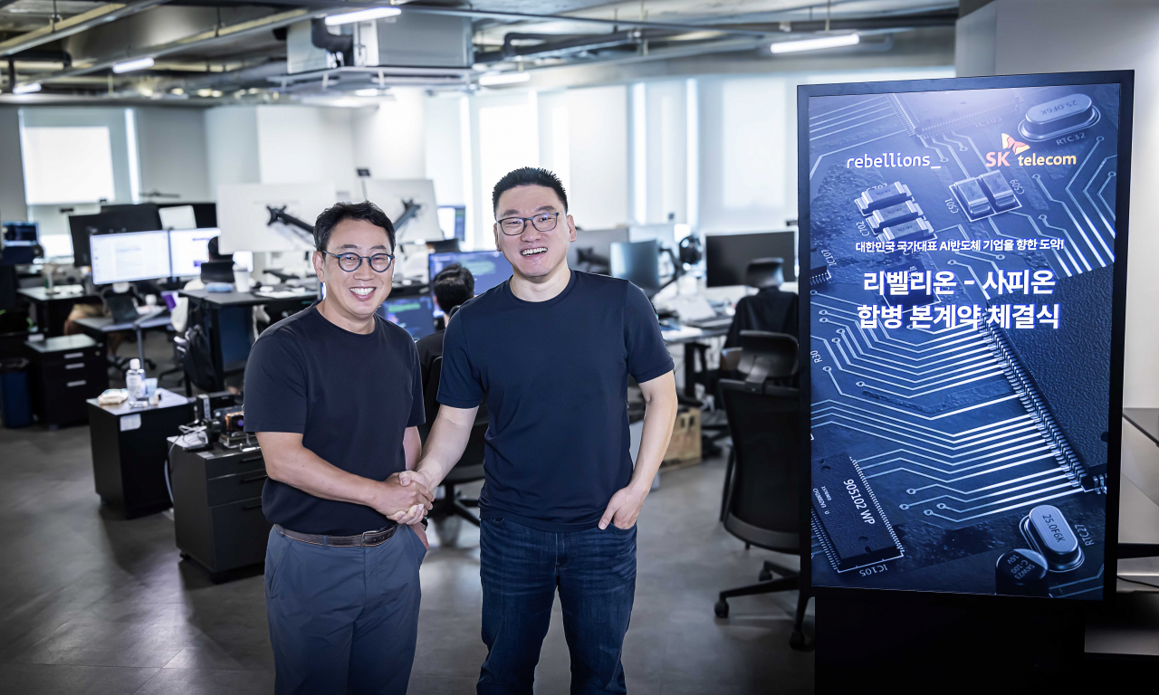 SK Telecom CEO Ryu Young-sang (left) and Rebellions CEO Park Sung-hyun shake hands at Rebellions headquarters in Seongnam, Gyeonggi Province, Friday. (SK Telecom)