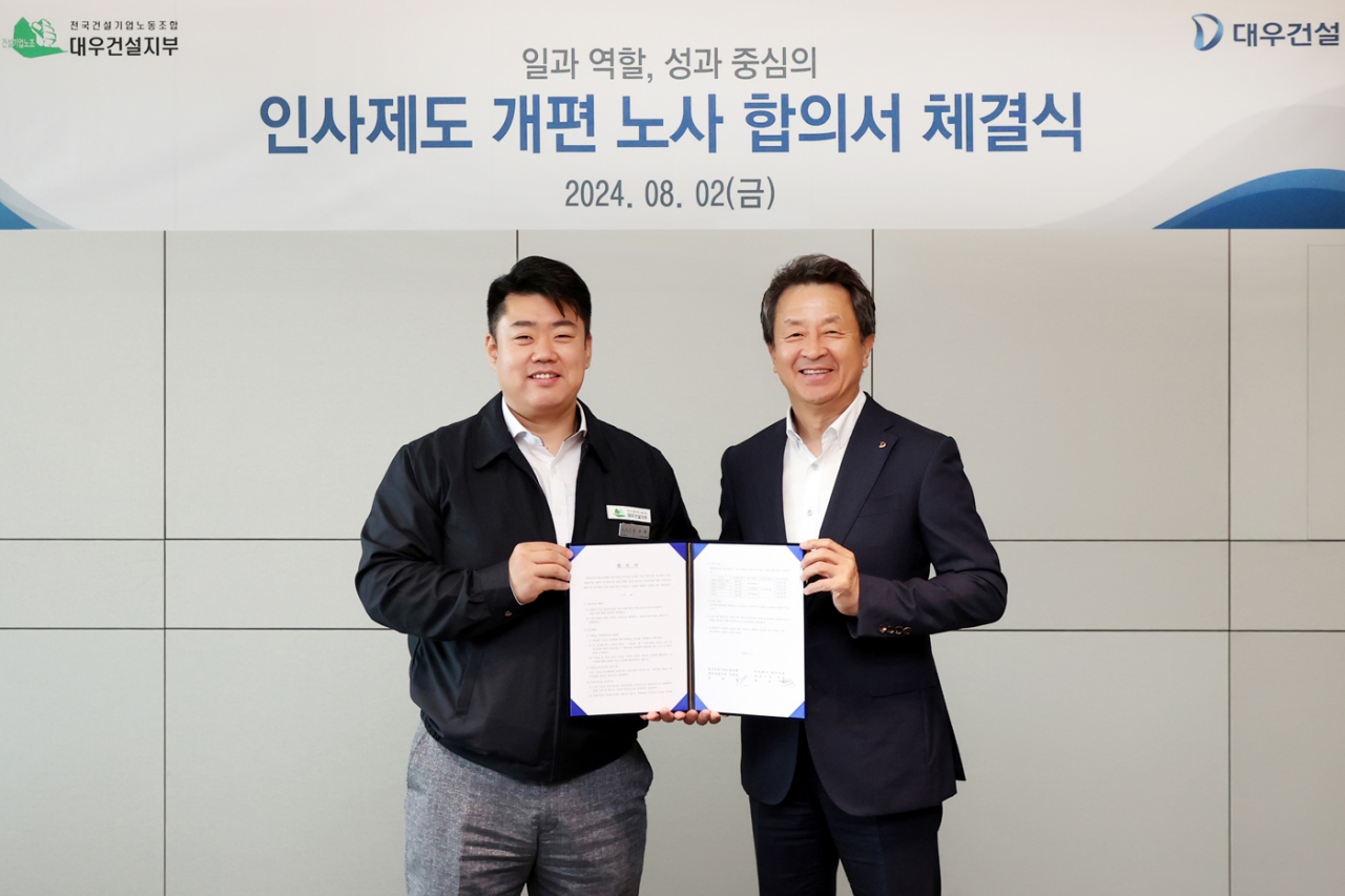 Daewoo Engineering & Construction's union head Shim Sang-chul (left) and the builder's CEO Baek Jeong-wan pose for a photo at a labor-management agreement ceremony held earlier this month. (Daewoo E&C)