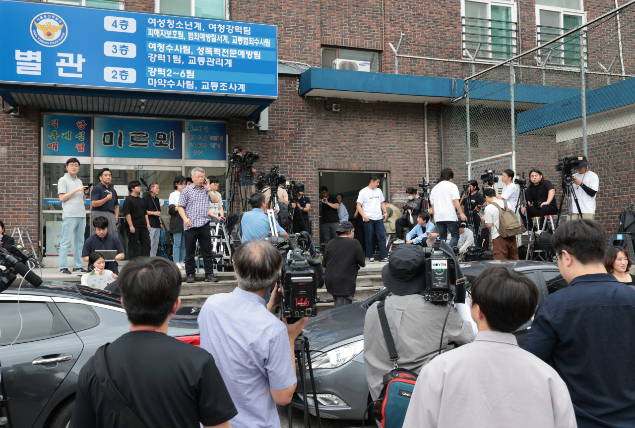 Reporters wait in front of the Seoul Yongsan Police Station Thursday morning for Suga of K-pop boy band BTS to appear for his first round of police questioning on charges of allegedly driving an electric scooter under the influence earlier this month. Yonhap