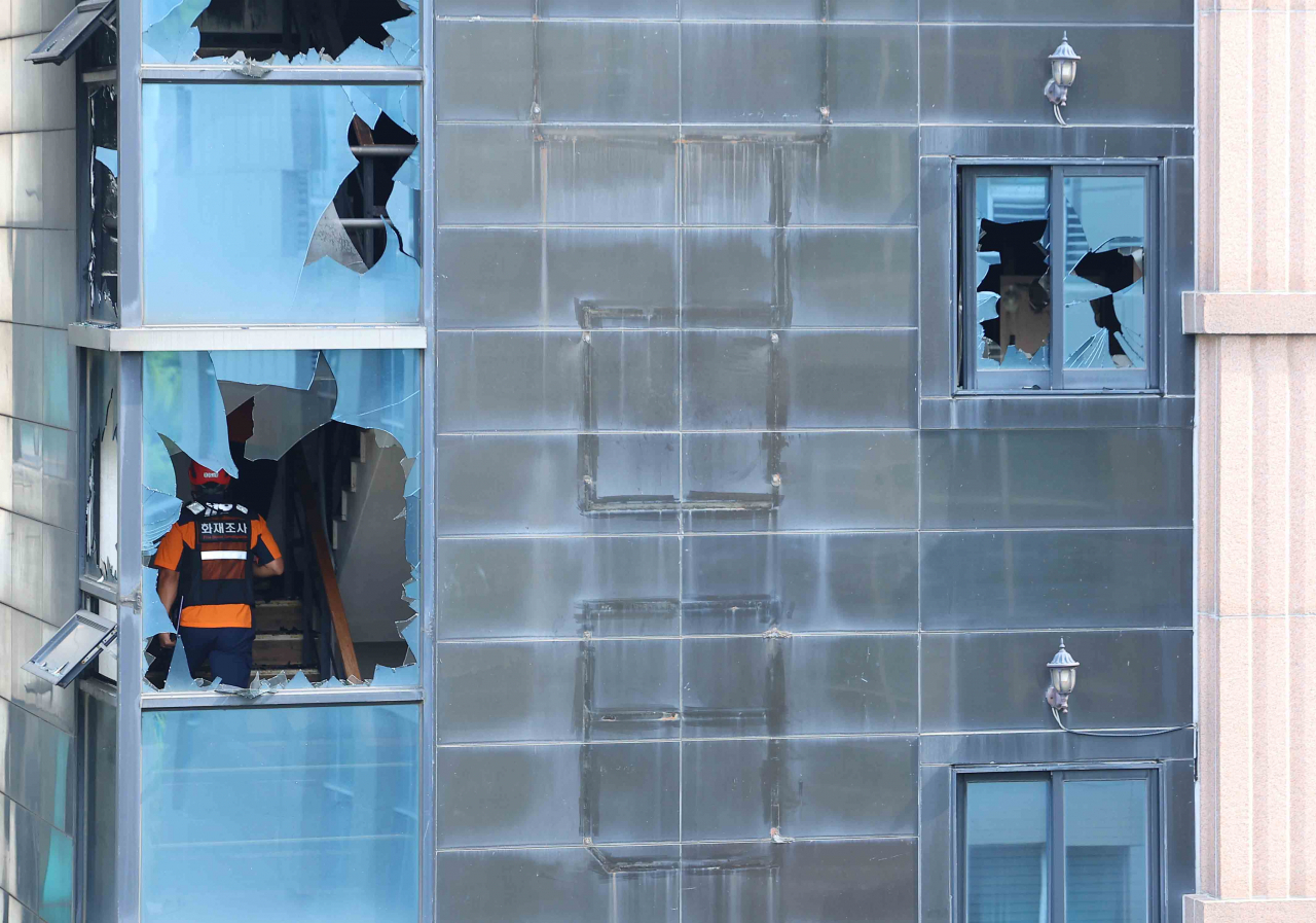 Fire officials inspect the scene at a hotel in Bucheon, Gyeonggi Province, on Friday morning, following a fire the previous day. (Yonhap)