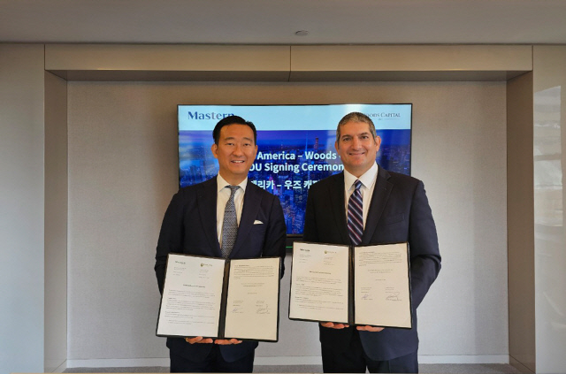 Mastern America CEO Joseph Oh (left) and Michael Woods, chairman of Woods Capital, pose for photos at a signing ceremony, held at the US subsidiary's office in New York, Thursday. (Mastern Investment Management)