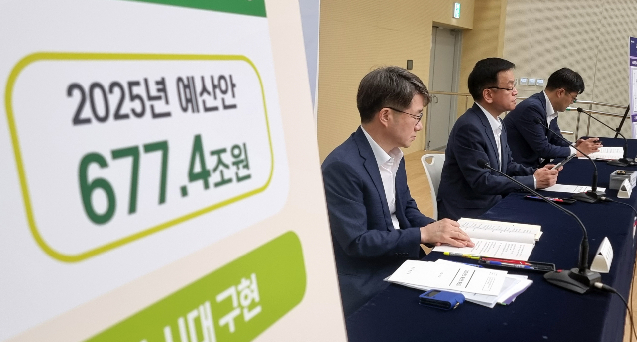 A 2025 spending budget of 677.4 trillion won ($509.2 billion) is shown on a board during the Finance Ministry's press briefing at the Sejong government complex last week. (Yonhap)