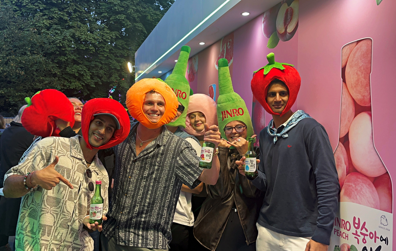 Visitors at the 2024 All Points East festival in London pose holding Hite Jinro's fruit liqueur products at the company's booth. (HiteJinro)