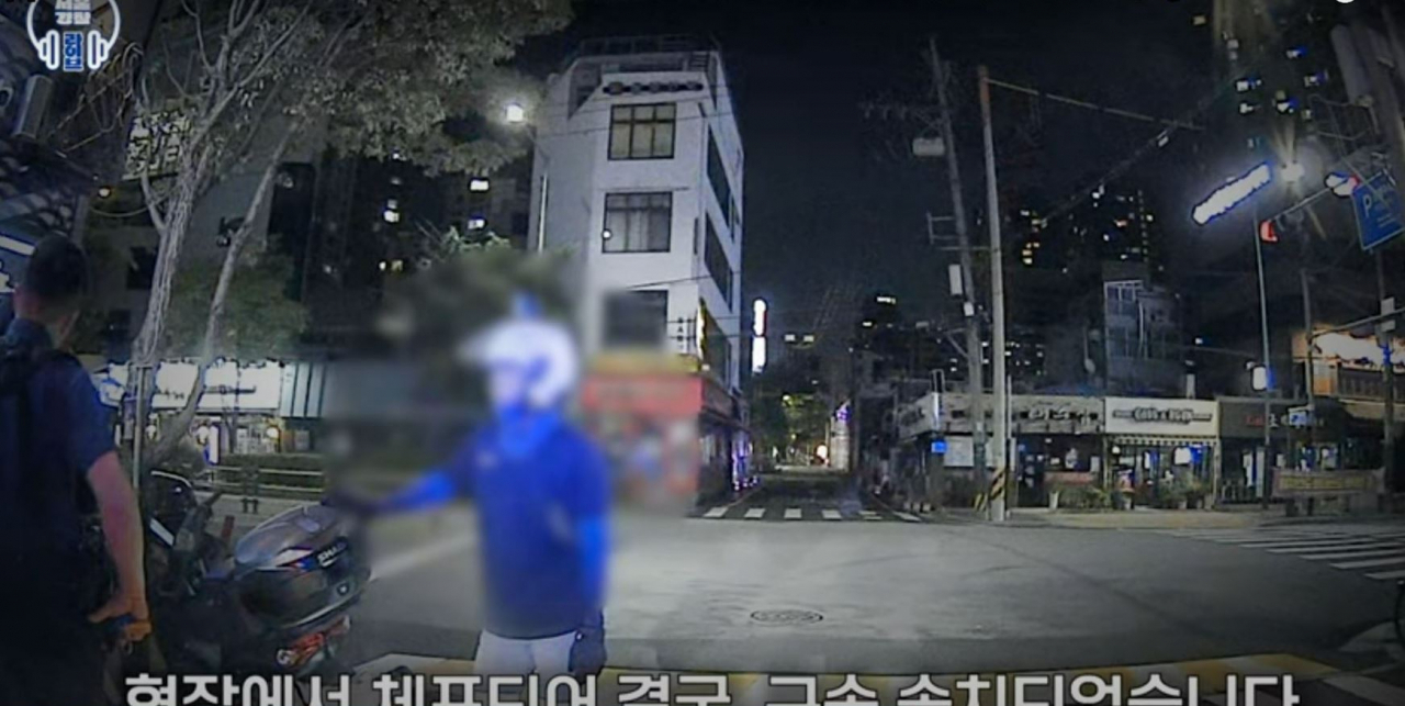 This screenshot from a video posted on Seoul Metropolitan Police Agency's official YouTube channel shows Lee (right), stopping the suspect who stole the bag of a woman as she was attempting to take her own life. (YouTube)