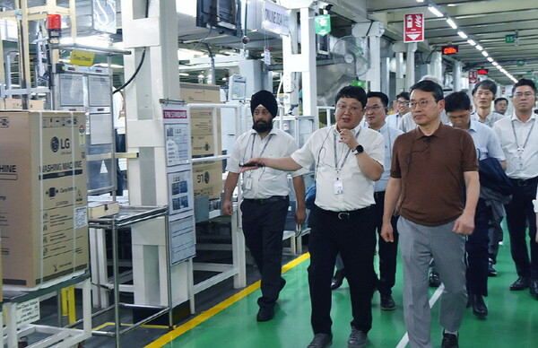 LG Electronics CEO Cho Joo-wan (right) inspects the company's key production facility for home appliances in India in June last year. (LG Electronics)