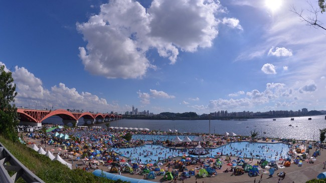 Mangwon Hangang Park’s swimming pool, one of the several outdoor pools along the Han River operated by the city, is packed with Seoulites trying to escape the heat in 2012. (Lee Sang-sub/The Korea Herald)