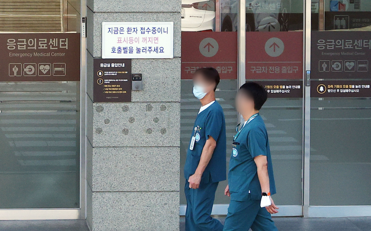 Medical workers pass by an emergency center in Seoul on Wednesday. (Yonhap)