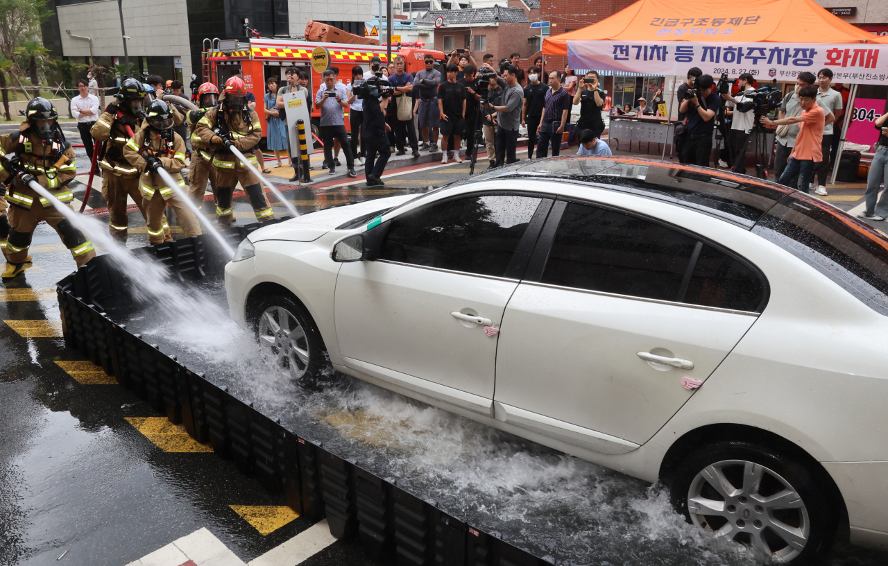 Fire authorities conduct a drill to put out an EV fire in Busan on Aug. 27. (Yonhap)