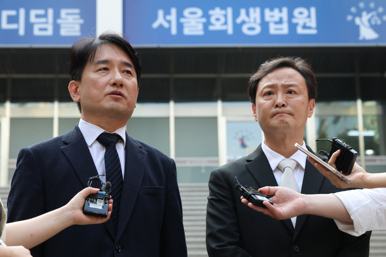 WeMakePrice CEO Ryu Hwa-hyeon (left) and Tmon CEO Ryu Kwang-jin speak to reporters upon the court's decision, in front of the Seoul Rehabilitation Court on Tuesday. (Yonhap)