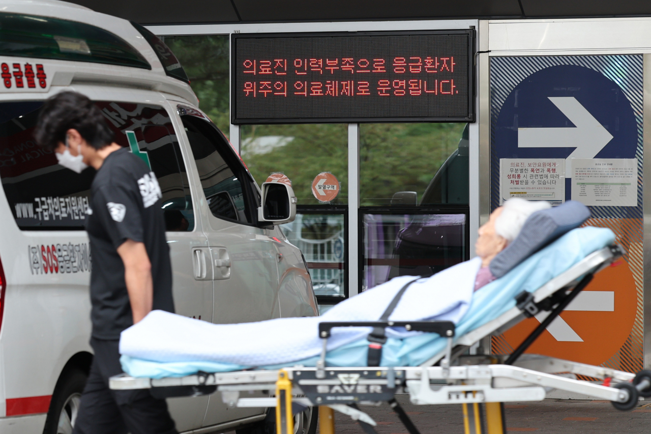 An emergency worker carries a patient to a Seoul-based university hospital on Thursday. (Yonhap)