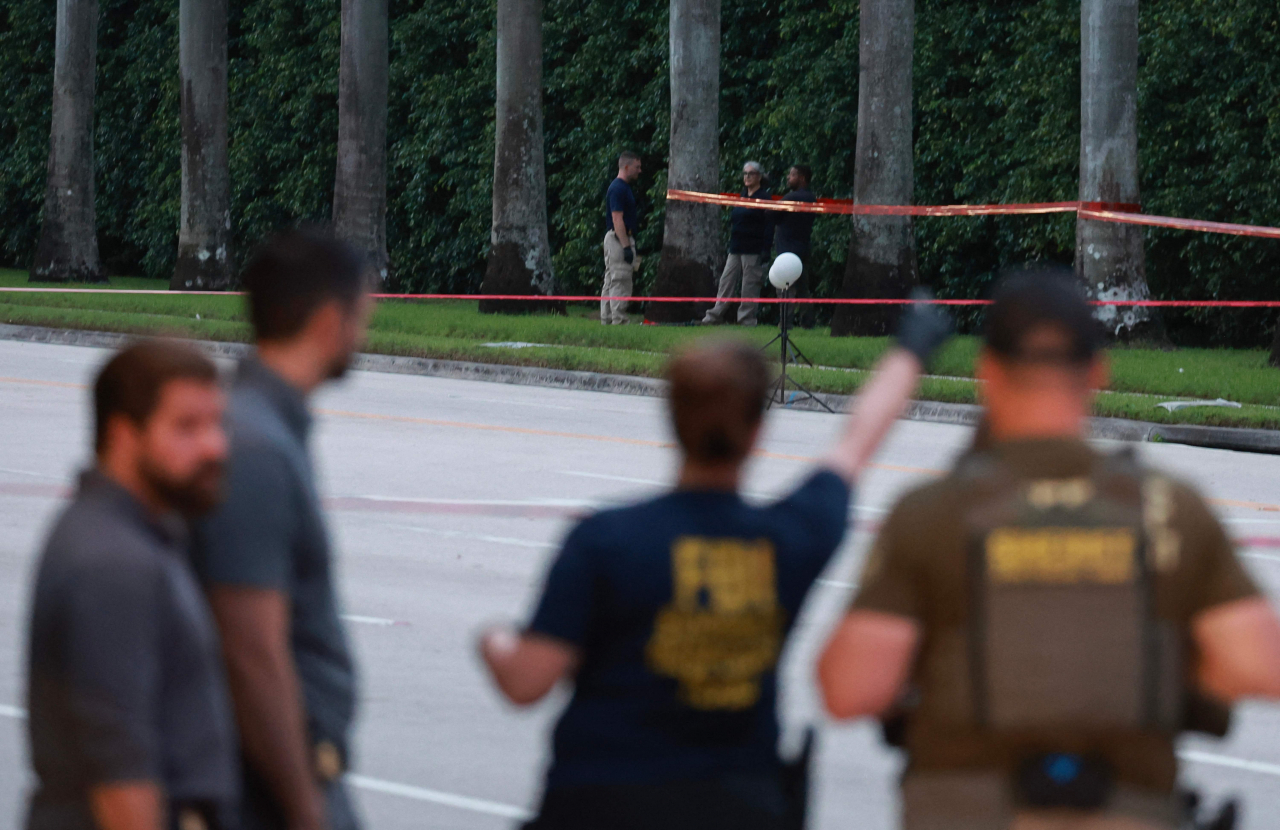 Law enforcement personnel investigate the area around Trump International Golf Club after an apparent assassination attempt of former US President Donald Trump on Sunday in West Palm Beach, Florida. The FBI and US Secret Service, along with the Palm Beach County Sheriff's office, are investigating the incident, which the FBI said 