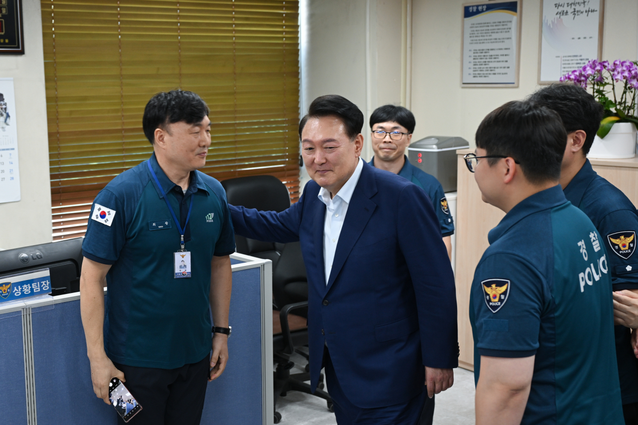 President Yoon Suk Yeol (center) encourages police officers who are on duty during the Chuseok fall harvest holiday, as he visited Gwanak Police Station in Seoul on Sunday. (Yonhap)