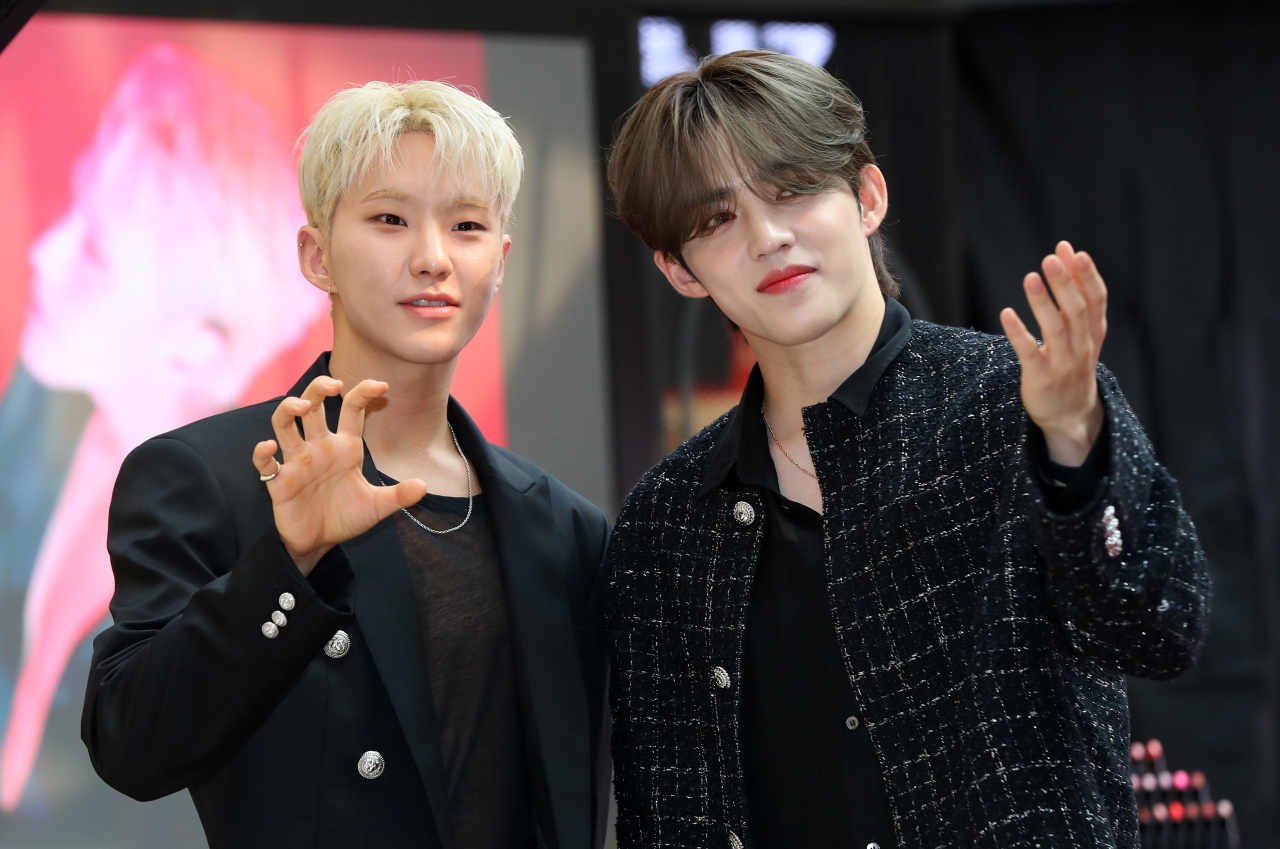 Hoshi and S.Coups of the group Seventeen pose for photos at the NARS Lipstick pop-up store event at Lotte Department Store in Seoul on Aug. 3. (Yonhap)