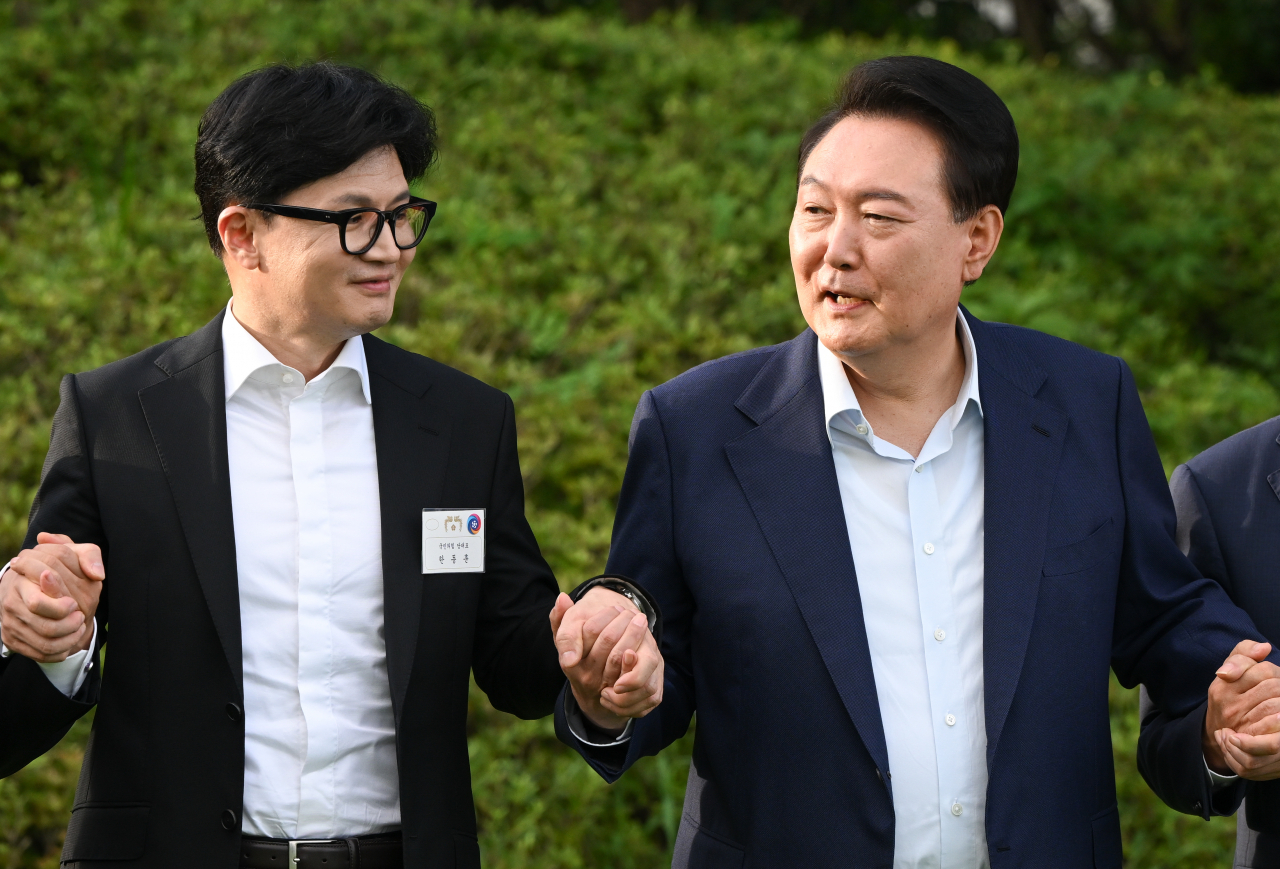 President Yoon Suk Yeol (right) and People Power Party Chair Han Dong-hoon shake hands during a dinner hosted by the presidential office on July 24. (Presidential Office)