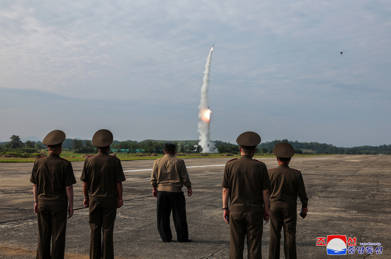 North Korean leader Kim Jong-un (center) inspects the test-fire of the Hwasongpho-11-Da-4.5, a new tactical ballistic missile, equipped with a 4.5-ton warhead on Wednesday, in this photo provided by the North's official Korean Central News Agency on Thursday. (Yonhap)