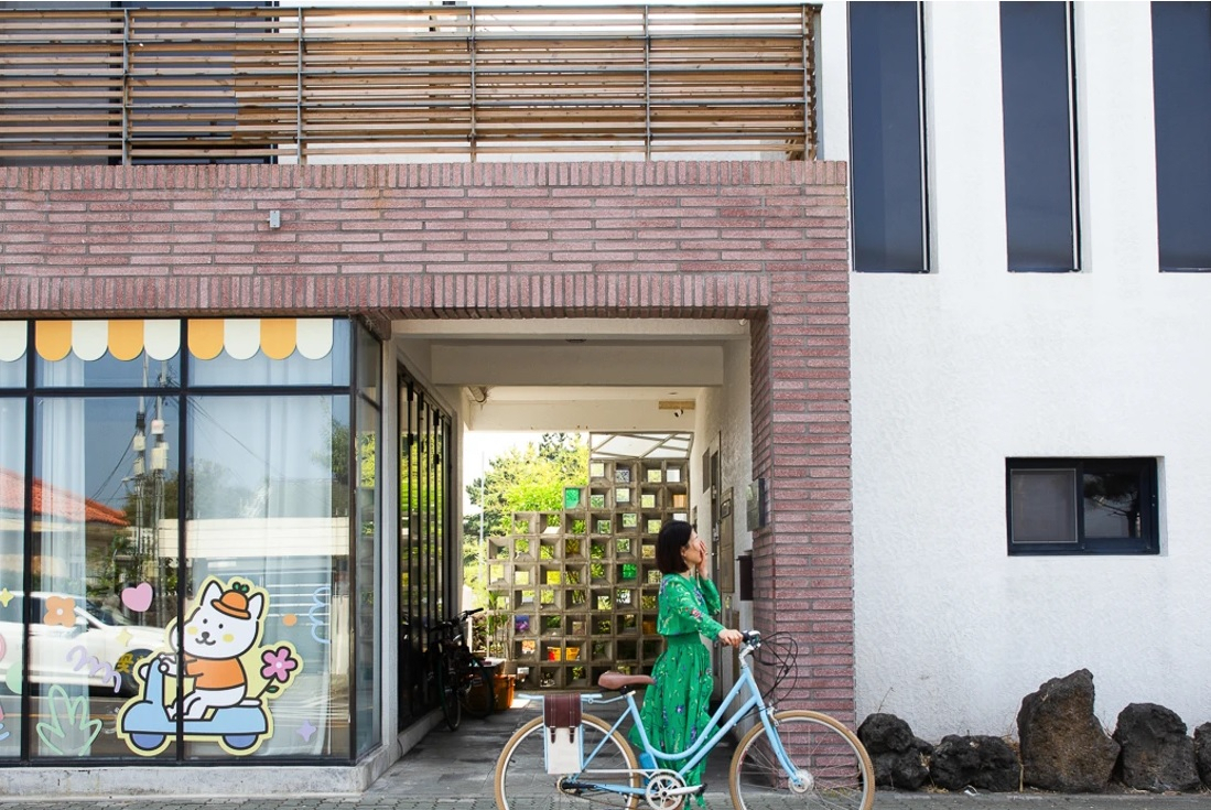 A guest poses for photos with her bicycle at Sinchang Bikely in Hangyeong-myeon, eastern Jeju Island. (Kareum Stay)