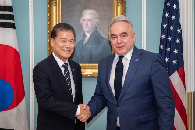 South Korea's Unification Minister Kim Yung-ho (left) and US Deputy Secretary of State Kurt Campbell shake hands during a meeting in Washington in July 2024. Both officials wear symbolic badges featuring three forget-me-not flowers, produced by the Unification Ministry. This emblem represents the 