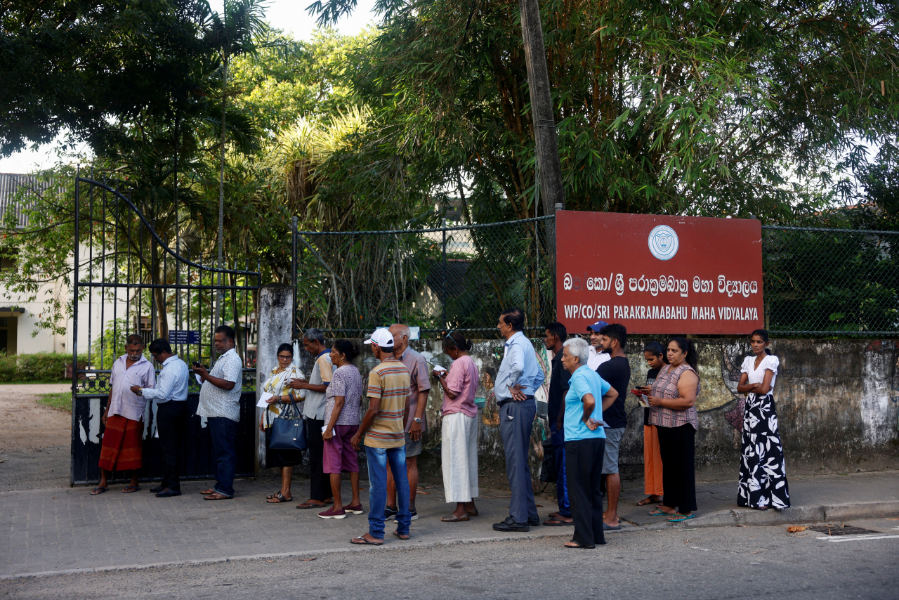 People stand in queue outside a polling station on the day of the presidential election in Colombo, Sri Lanka, Saturday. (Retuers)