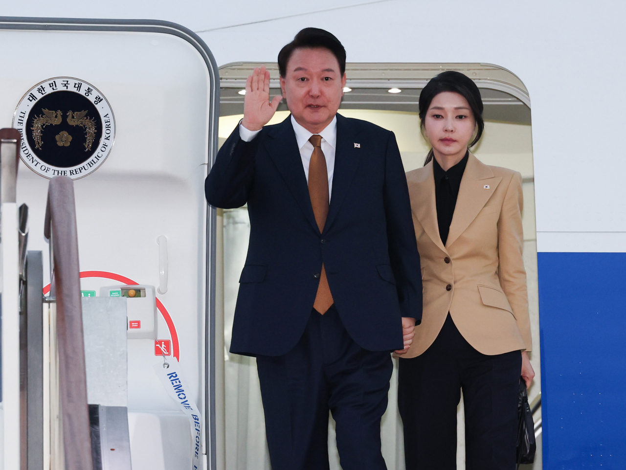 President Yoon Suk Yeol (left) and first lady Kim Keon Hee arrive at Seoul Airport in Seongnam, south of Seoul, on Sunday, returning from their trip to the Czech Republic. (Yonhap)