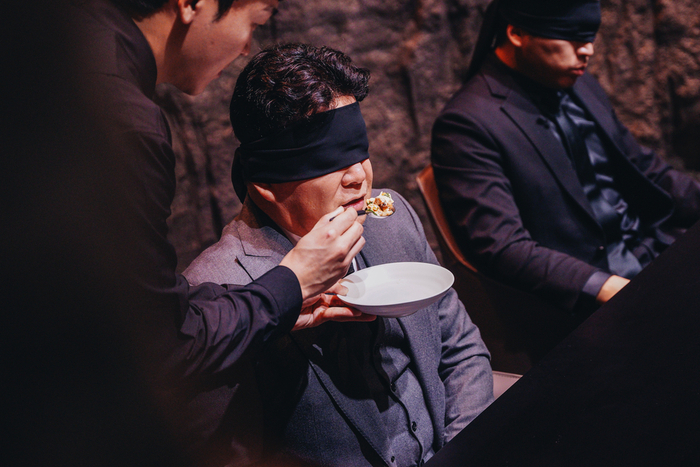 Star restaurateur Paik Jong-won, blindfolded, tastes a dish created by a contestant in 