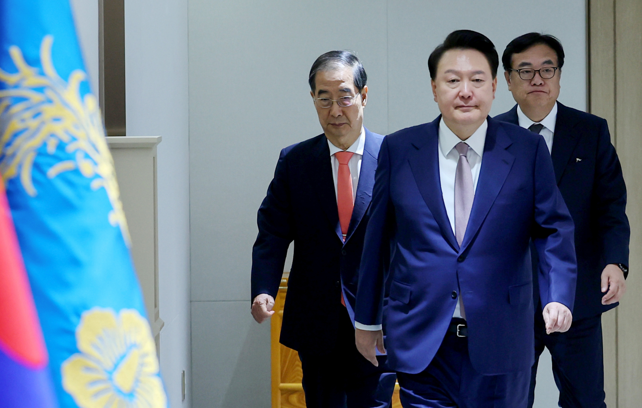 President Yoon Suk Yeol (second from left) enters the meeting room to preside over a Cabinet meeting in his office in Seoul Tuesday. (Yonhap)