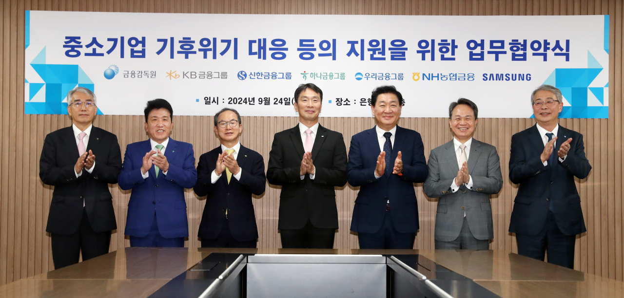 Korea's major financial groups, Samsung Electronics and the Financial Supervisory Service have joined forces to support small- and medium-sized enterprises to enhance their readiness for climate change. (From left) NongHyup Financial Group Chairman Lee Suk-joon, Hana Financial Group Chairman Ham Young-joo, KB Financial Group Chairman Yang Jong-hee, Financial Supervisory Service Gov. Lee Bok-hyun, Samsung Electronics Vice Chairman Han Jong-hee, Shinhan Financial Group Chairman Jin Ok-dong and Woori Financial Group Chairman Yim Jong-ryong pose for a photo during the launch event of a 2 trillion won ($1.5 billion) green growth fund for SMEs in Seoul on Tuesday. (Joint Press Corps)