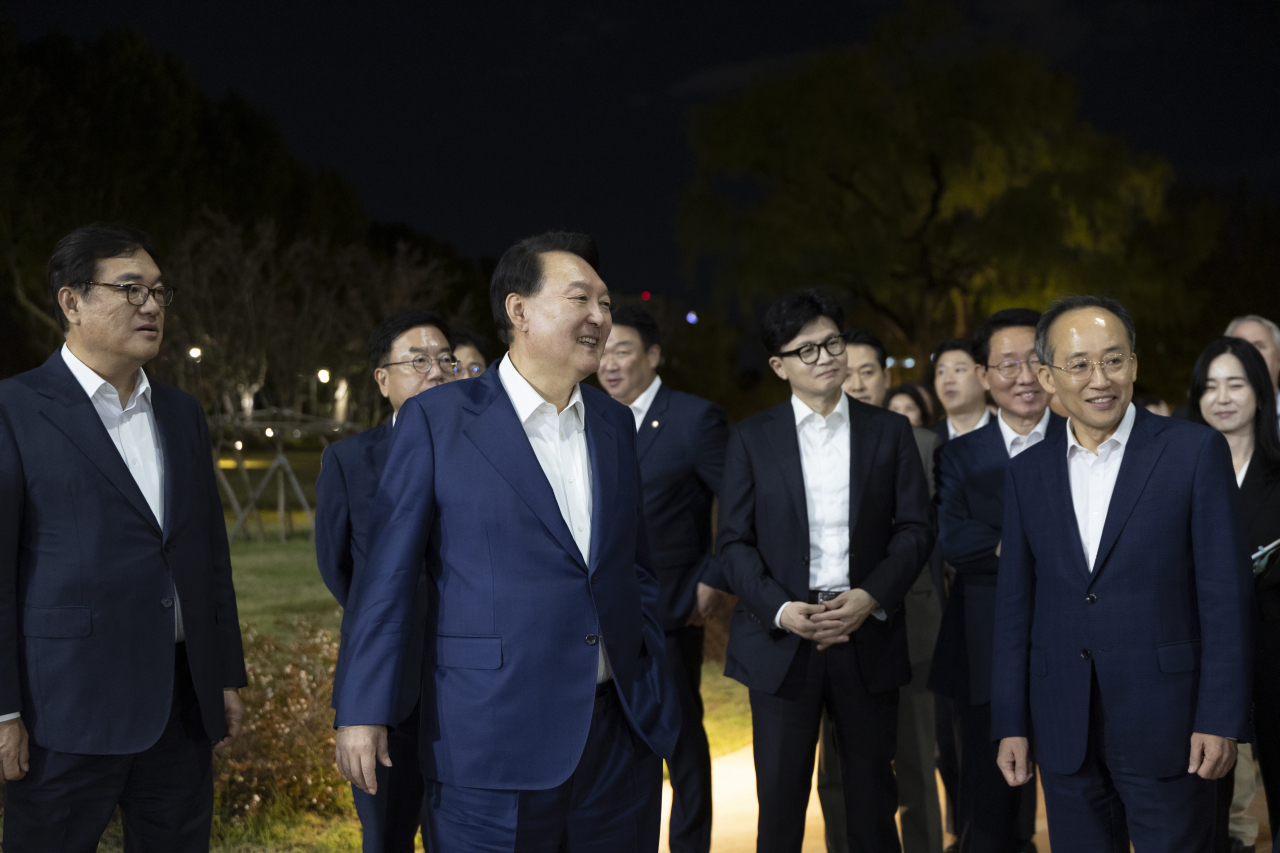 President Yoon Suk Yeol, center left, takes a walk with the ruling People Power Party leadership after a dinner meeting held in Yongsan on Tuesday. (Yonhap)