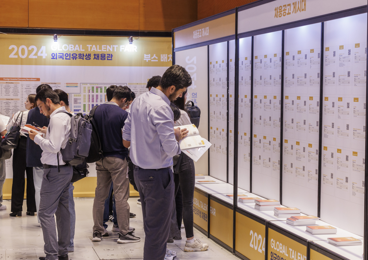 Foreign national students read hiring notices at a job fair in Seoul, Aug. 27. (Yonhap)