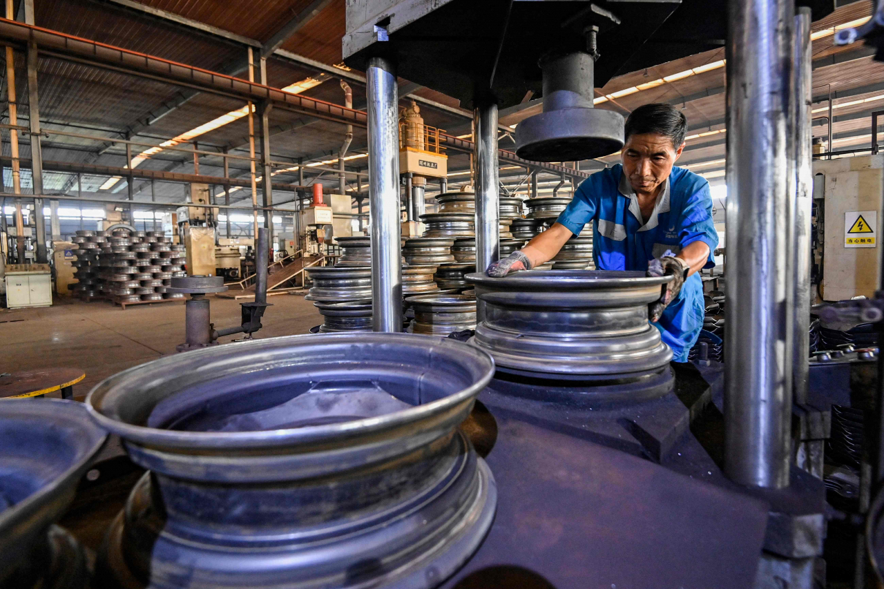 An employee works on a steel wheel production line at a factory in Qingzhou, in eastern China's Shandong province on Sept. 27, 2024. (AFP)