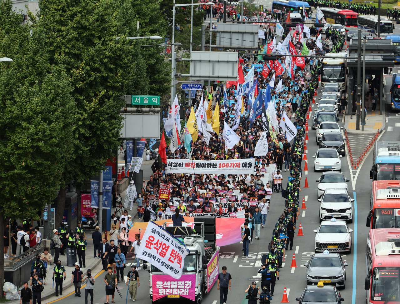 Protesters calling for President Yoon Suk Yeol's resignation march along a street near Seoul Station Saturday. (Yonhap)