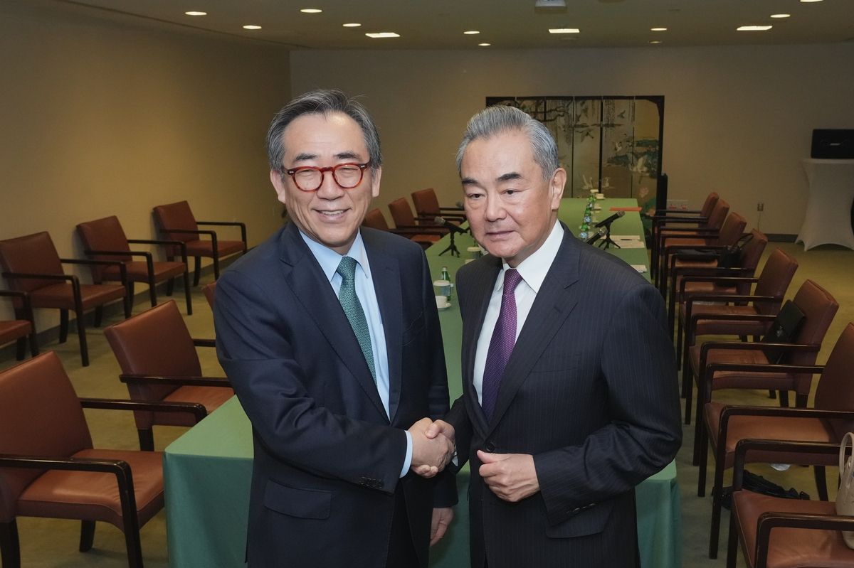 Foreign Minister Cho Tae-yul (left) and his Chinese counterpart, Wang Yi, shake hands before their meeting in New York on Saturday, in this photo provided by his ministry. (Yonhap)