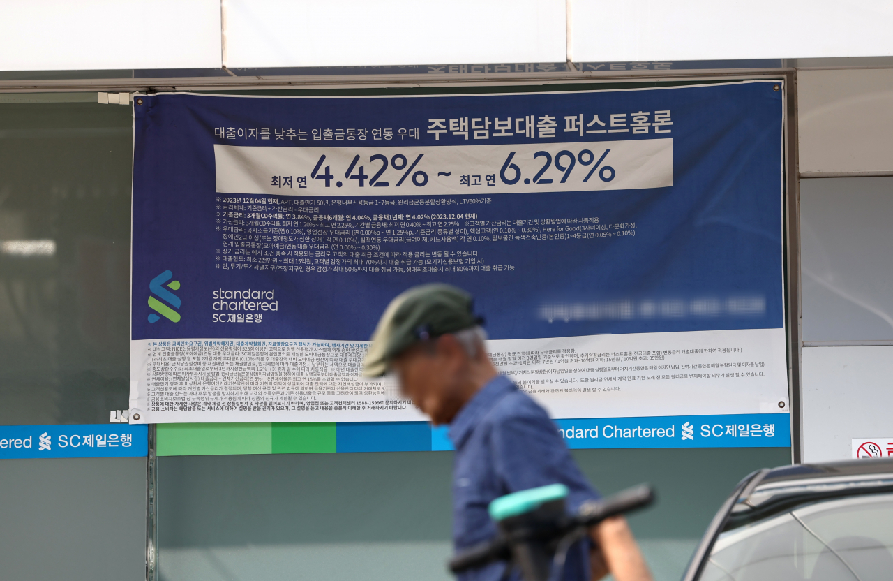 A man walks by a banner promoting a loan product of a Seoul-based bank on Sept. 18. (Yonhap)