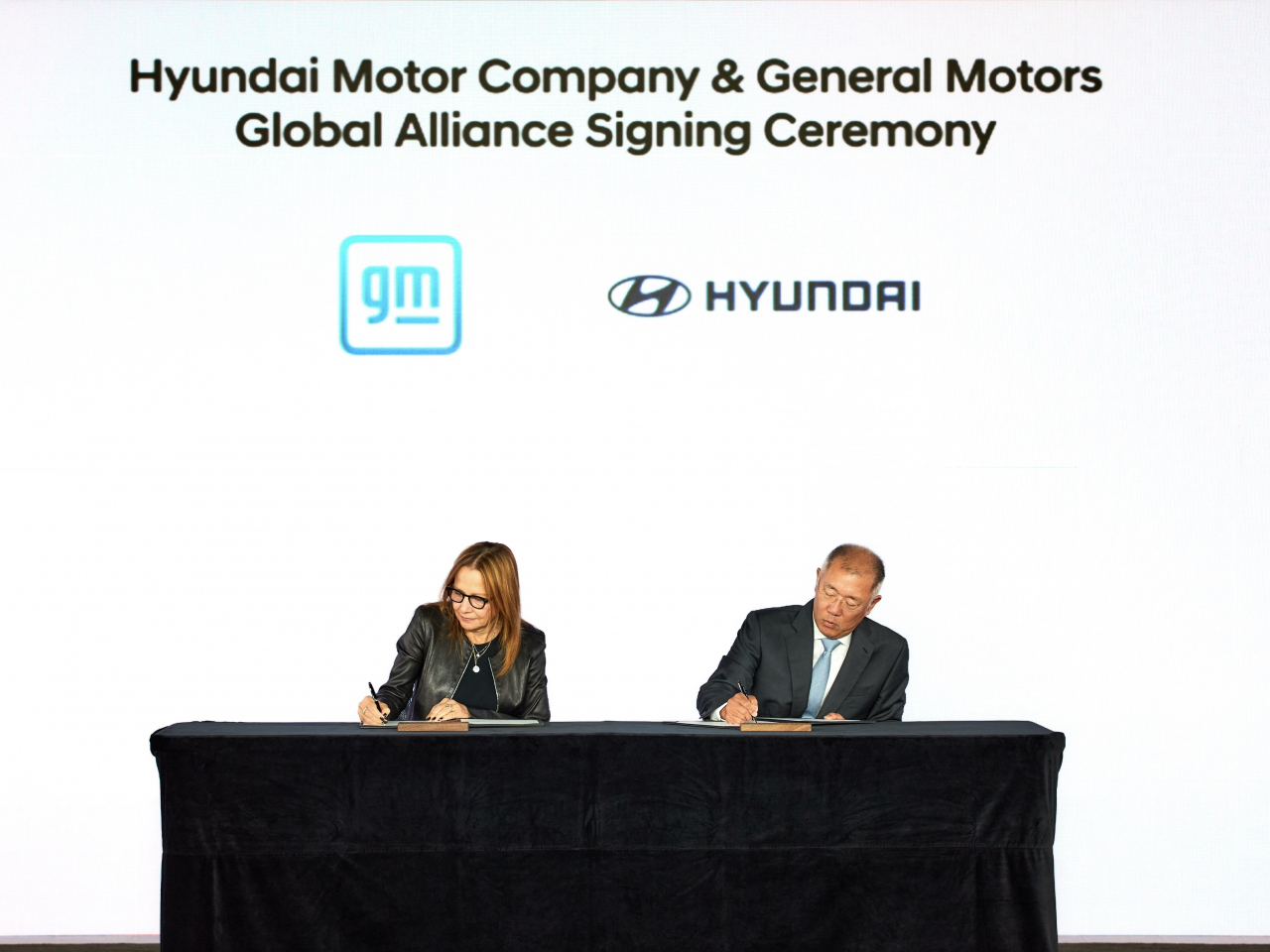 Hyundai Motor Group Executive Chair Chung Euisun (right) and General Motors CEO Mary Barra sign a comprehensive partnership agreement between the two automotive giants at Genesis House New York on Sept. 12. (Hyundai Motor Group)