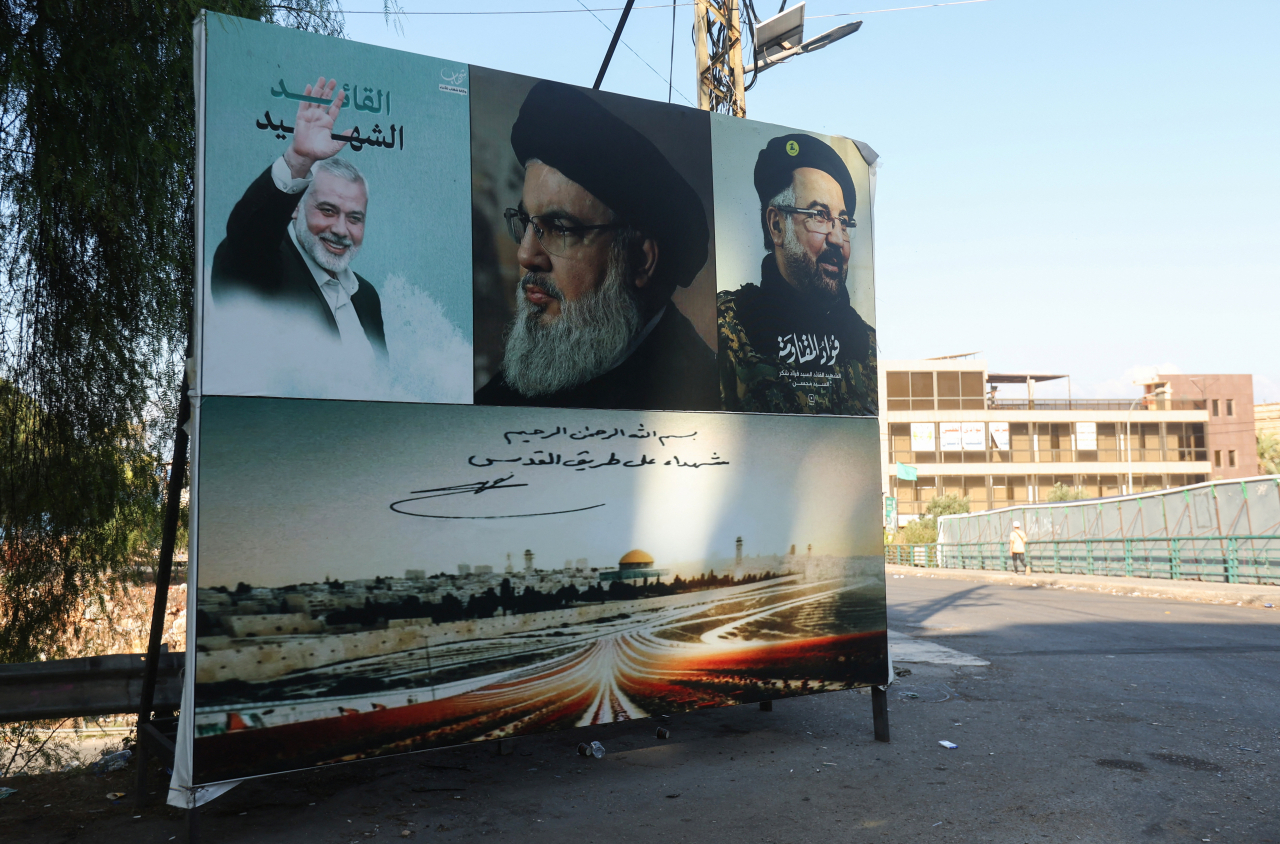 A poster depicting late Hamas leader Ismail Haniyeh, Hezbollah leader Sayyed Hassan Nasrallah and Hezbollah top commander Fuad Shukr is seen in Wadi El Zayni, Lebanon, Sunday. (Reuters-Yonhap)