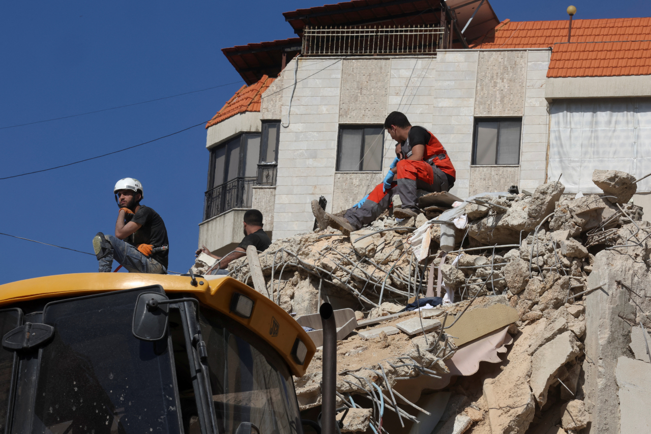 Emergency personnel at the site of Sunday's Israeli attack on the city of Ain Deleb, amid the ongoing hostilities between Hezbollah and Israeli forces, in southern Lebanon. (Reuters-Yonhap)