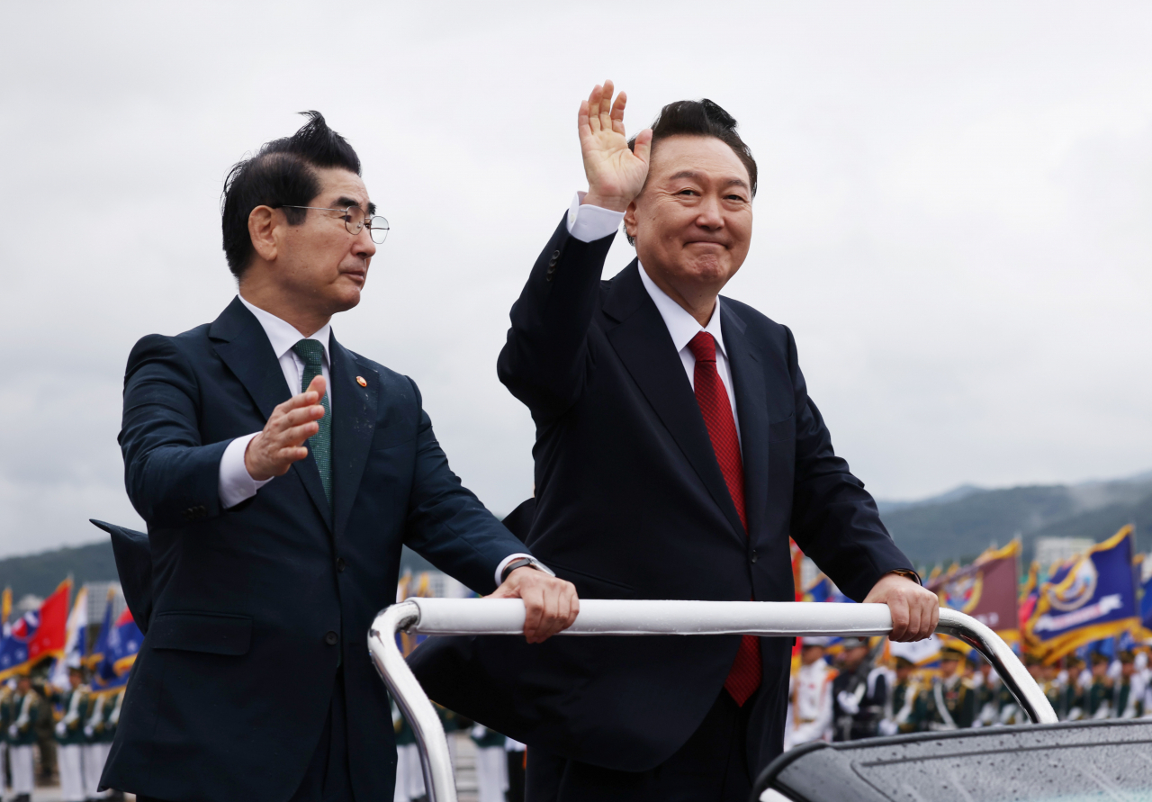 President Yoon Suk Yeol (right) waves to a crowd during the Armed Forces Day ceremony held at Seoul Air Base on Tuesday. On his left is Minister of National Defense, Kim Yong-hyun. (Yonhap)