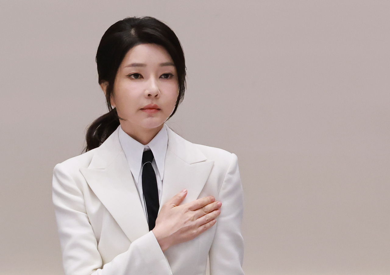 First lady Kim Keon Hee crosses her heart as she faces the national flag at a lunch event to celebrate the return of Team South Korea from the 2024 Paralympic Games, at Cheong Wa Dae in Seoul, Sept. 13. (Yonhap)