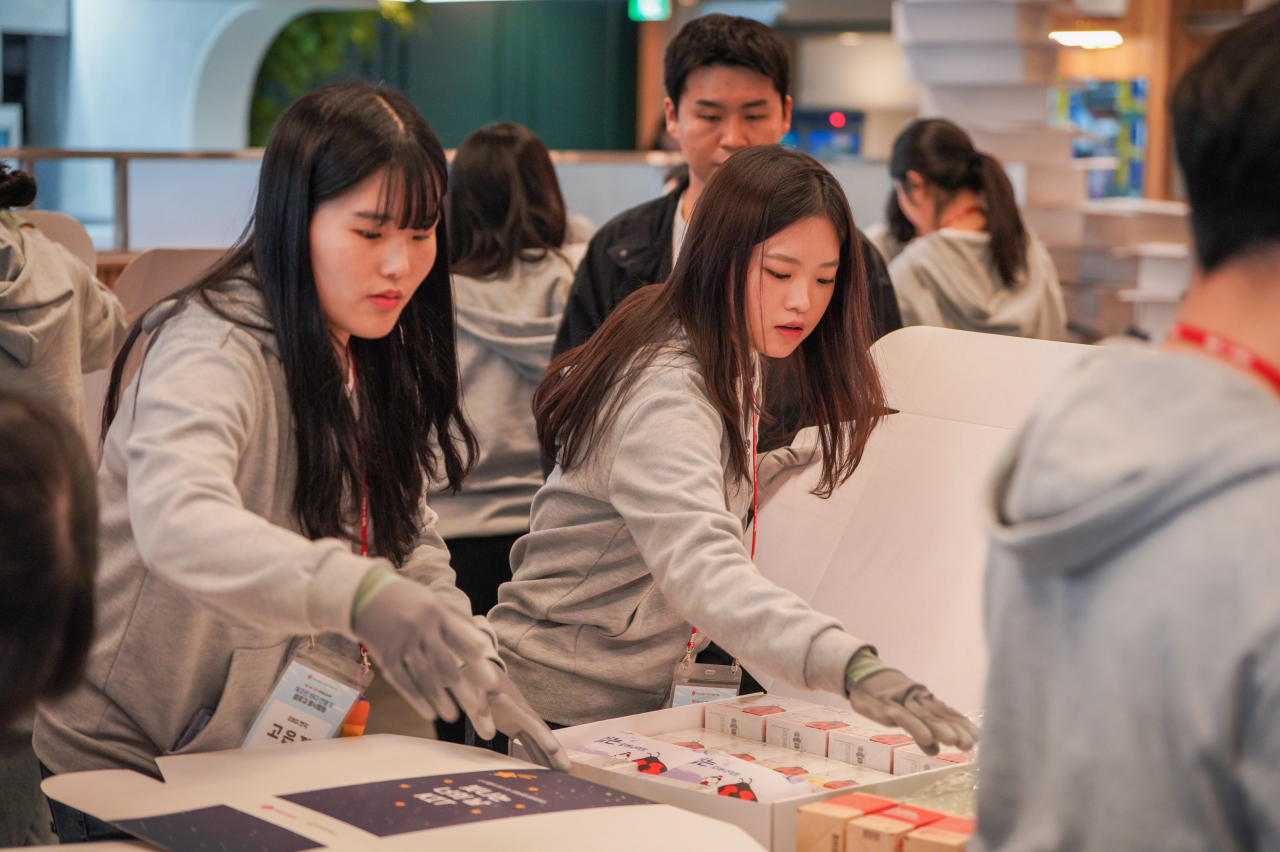 Volunteers of the Value Creators in Universities program package women's products at Lotte Chilsung Beverage's Gangneung plant in February. (Lotte Corporation)