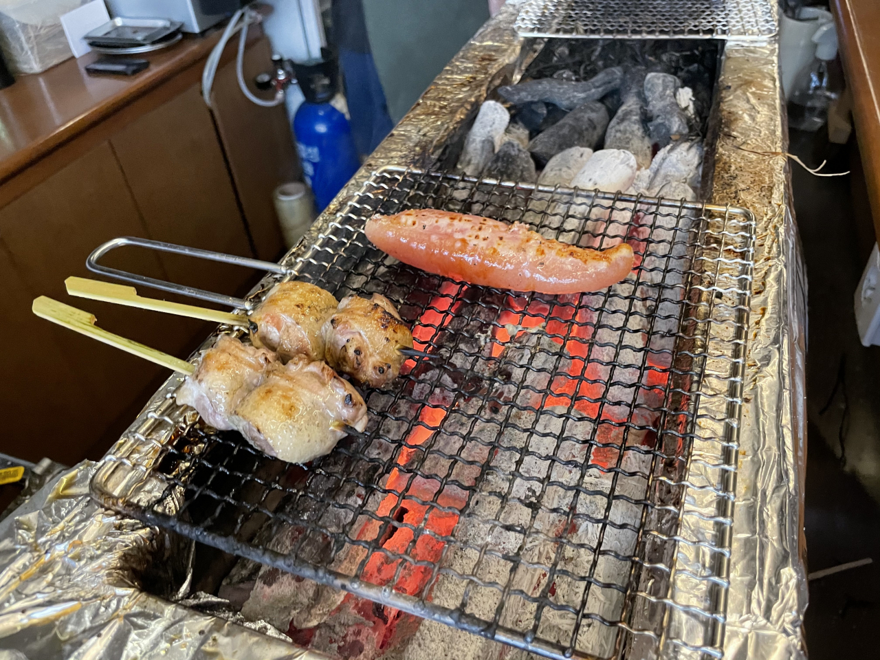 Chicken skewers and pollack roe are grilled over charcoal at Atari in Seongsu-dong, eastern Seoul, Saturday. (Kim Jae-heun/The Korea Herald)