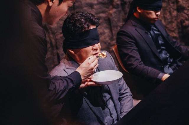 Star restaurateur Paik Jong-won, blindfolded, tastes a dish created by a contestant in 