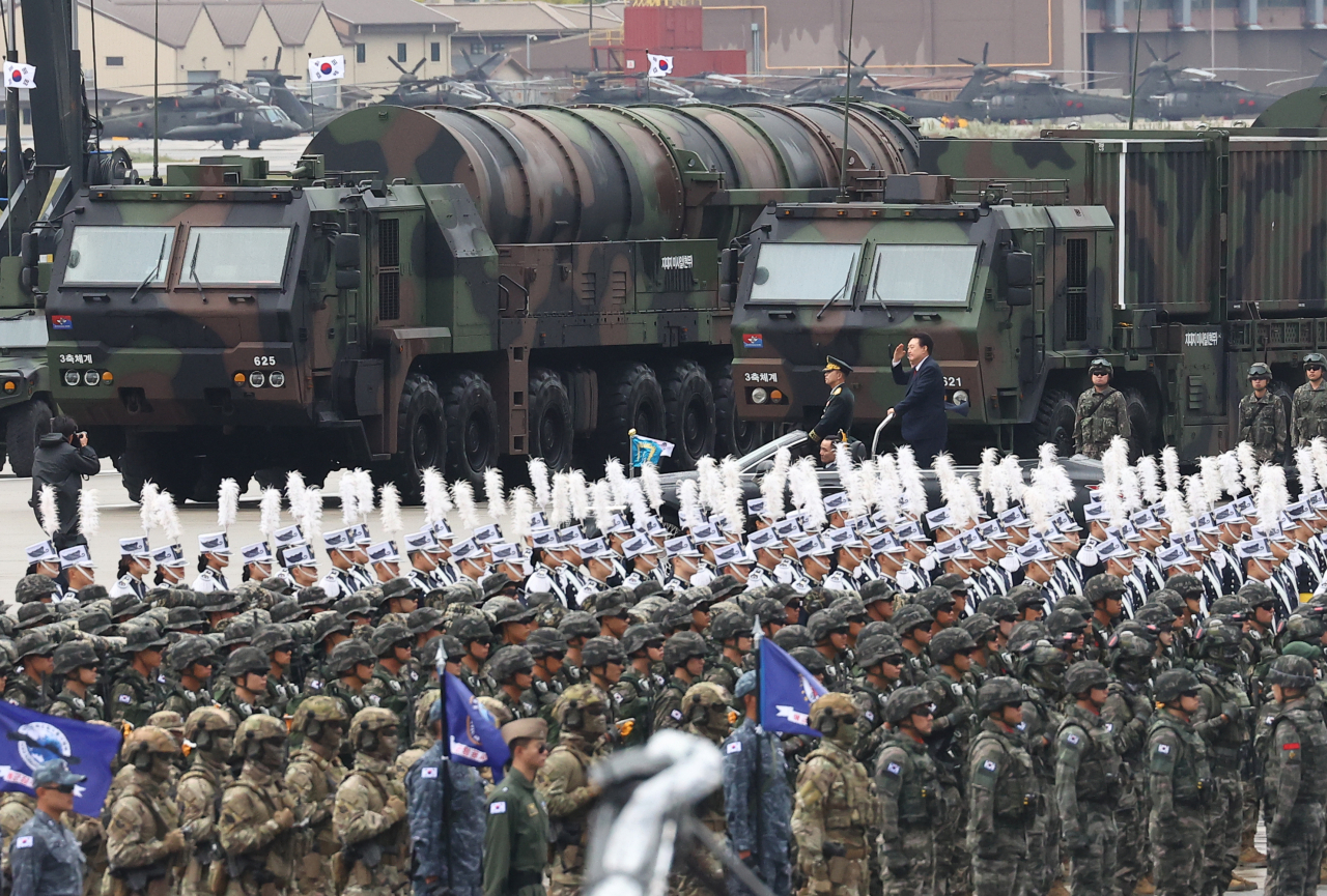 President Yoon Suk Yeol (back) salutes as he passes a transporter erector launcher carrying a Hyunmoo-5 missile, while inspecting troops gathered for a ceremony to mark Armed Forces Day at Seoul Air Base in Seongnam, Gyeonggi Province, Tuesday. (Pool photo via Yonhap)